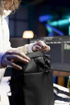 Admin packing backpack at end of day after securing company servers Stock Photos