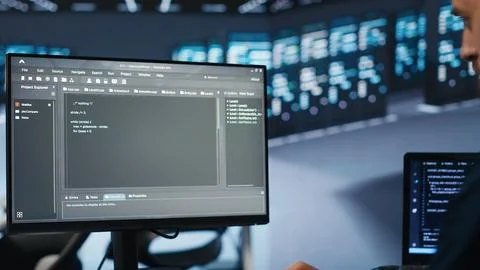 Admin running coding script on computer screen in high tech data center, Stock Photos