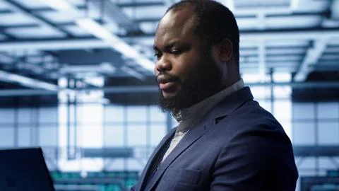 Admin in server farm using laptop to patch network issues, close up Foto stock