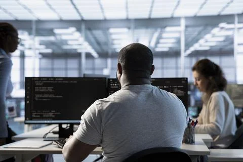 Admin in server hub next to colleagues protecting data against hacking attacks Stock Photos