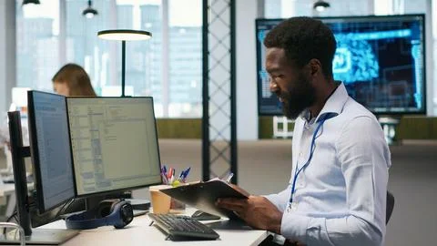 Admin in tech startup office using PC, compiling software patches to fix bugs Stock Photos