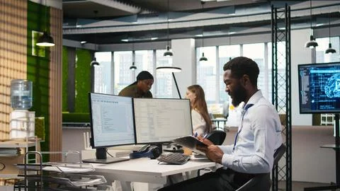 Admin in tech startup office using PC, compiling software patches to fix bugs Stock Photos