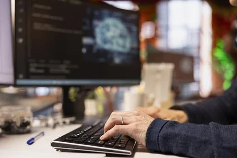 Admin typing on PC keyboard in startup office, coding advanced AI algorithm Stock Photos
