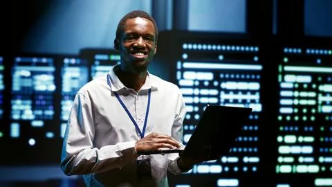 Admin using laptop to audit servers Foto stock