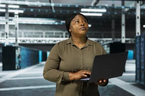 Admin using laptop to do maintenance in data center Foto stock
