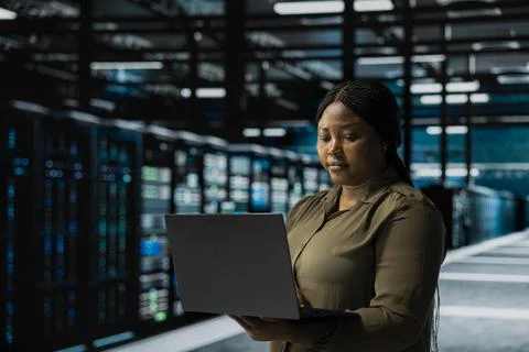 Admin using laptop to implement security measures in data center 스톡 사진