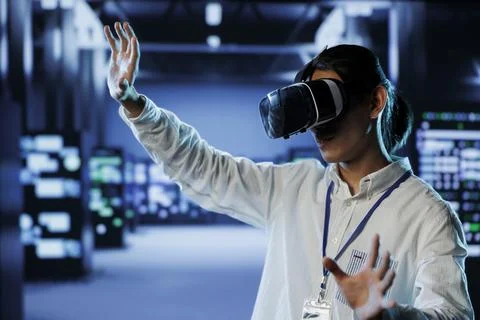 Admin with VR headset monitors servers 写真素材