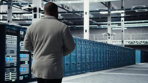 Admin walking in data center, doing inspection on infrastructure tech Stock Photos