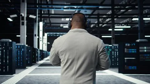 Admin walking in data center, listening music while doing inspection Stock Photos