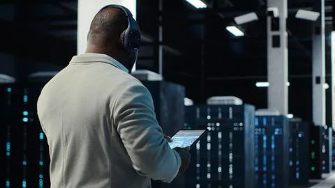 Admin walking in data center, listening music while doing inspection Stock Photos
