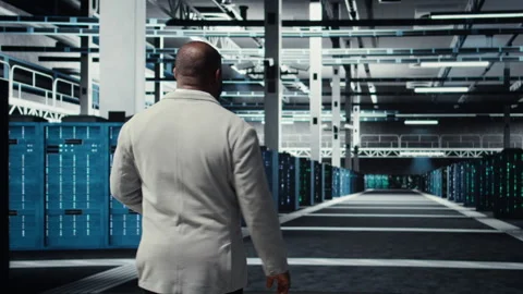 Admin walking in high tech data center facility with rows of supercomputers Stock Footage 311833173