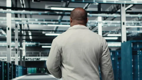 Admin walking in high tech data center facility with rows of supercomputers Stock Footage 311961761