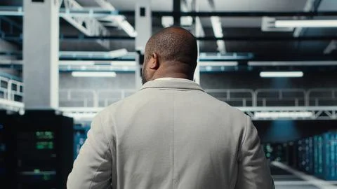 Admin walking in high tech data center facility, checking equipment Stock Photos