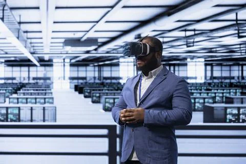 Admin working in data center, using VR headset to configure network Stockfoto's