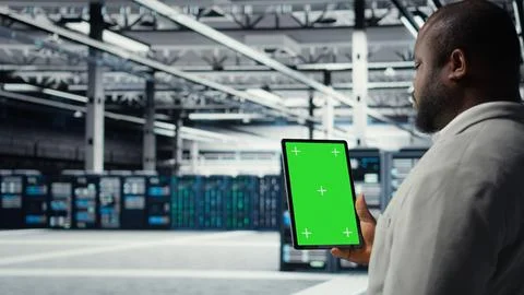 Admin working in server farm using isolated screen tablet to analyze data Stock Photos