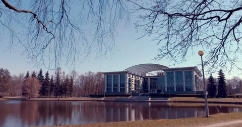 Administration building in a city park in front of a lake, among trees Stock Footage 119618288