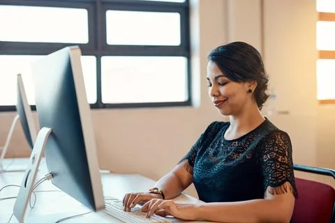 Administration, computer and typing with designer woman at desk in office for 写真素材