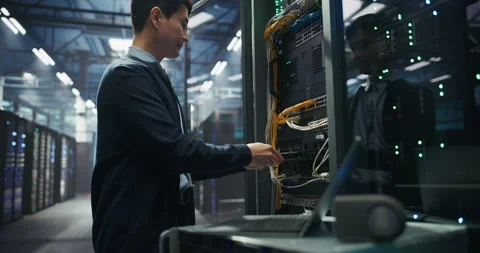 Administrator Inserting Hardware in Server Racks in Data Center Stock Footage 319999866