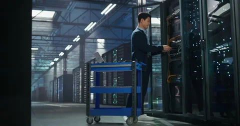Administrator Inserting Hardware in Server Racks in Data Center Stock Footage 320000427