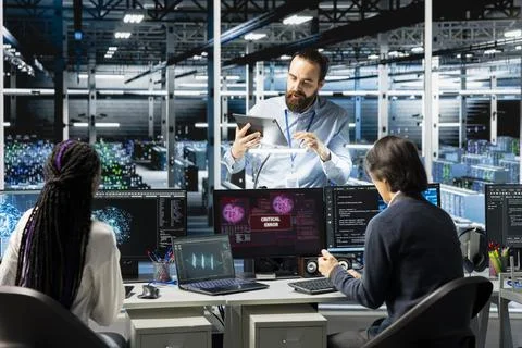 Admins in data center see critical error warning, troubleshooting rigs using AI Stock Photos
