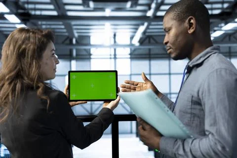 Admins in data center using mockup tablet, reviewing infrastructure health Stock Photos