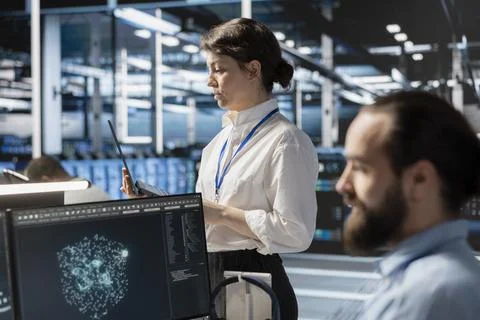 Admins using computer in data center office, running scripts Stock Photos