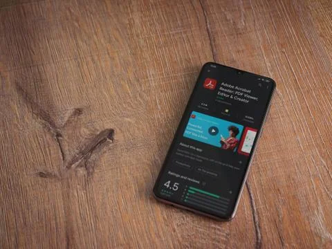Adobe Acrobat Reader app play store page on the display of a black mobile sma Stock Photos