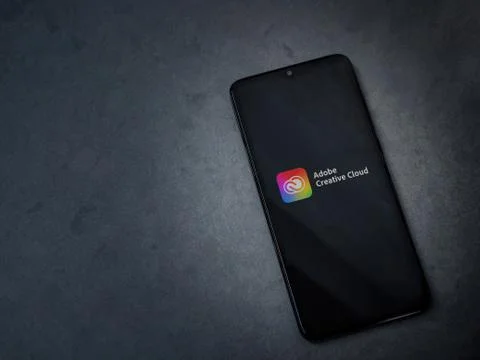 Adobe Creative Cloud app launch screen with logo on the display of a black mo Foto stock
