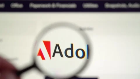 Adobe home page. The Adobe logo is visible through a magnifying glass Vidéo 153099464