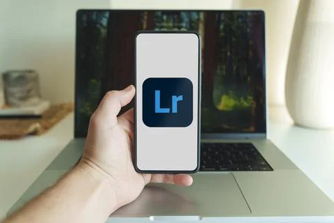 Adobe Lightroom photo editing application logo on smartphone screen in front of Stock Photos