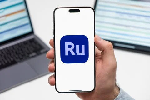 Adobe Premiere Rush logo on the screen of smartphone in mans hand on the Stock Photos