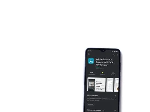 Adobe Scan app play store page on the display of a black mobile smartphone is Stock Photos