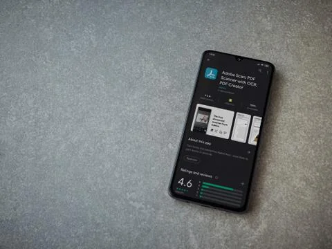 Adobe Scan app play store page on the display of a black mobile smartphone on Stock Photos