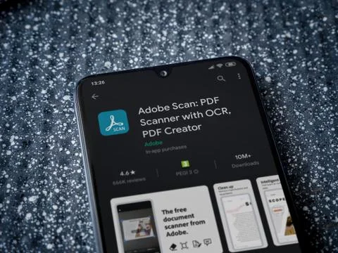 Adobe Scan app play store page on the display of a black mobile smartphone on Stock Photos