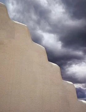 Adobe wall with storm clouds Stock Photos