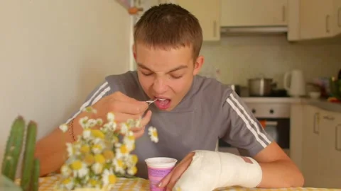 Adolescent boy with plaster tests dairy product around succulent plants Stock Footage 321028003