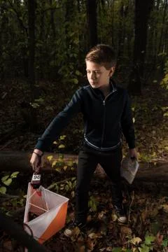 Adolescent checking to a control point in orienteering competition Stock Photos