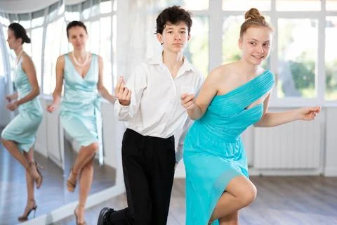 Adolescent couple practicing swing dance steps in mirrored studio Stock Photos