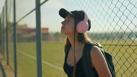 Adolescent looking up feeling warm evening sunlight near a sports boundary. Stock Footage 339810191