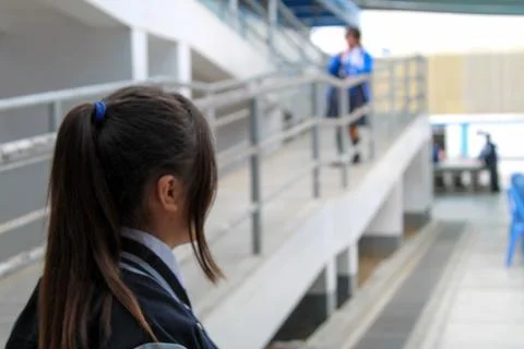Adolescente de espaldas mirando el colegio Foto stock