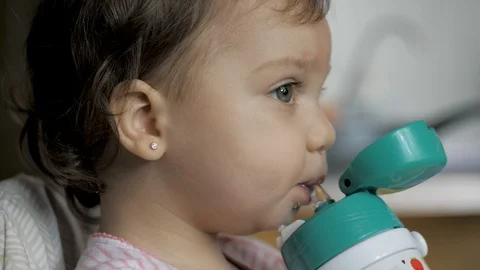Adorable baby girl drinking water from bottle with a straw Stock Footage