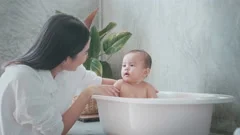 woman and baby taking bath in river - Gu, Stock Video