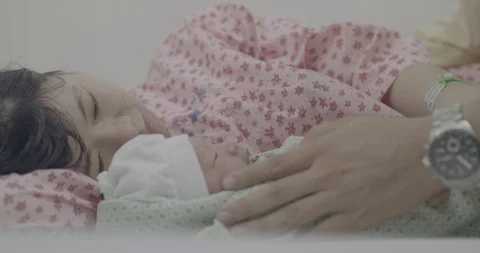 Adorable baby lying on bed surrounded with caring parents in the Maternity ho Stock Footage 127765649