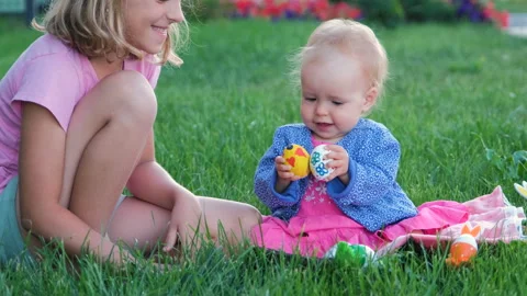 Adorable baby playing with Easter eggs on grass Stock Footage 261198167