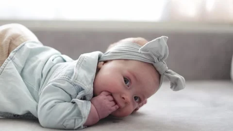 Adorable baby playing on a soft surface with expressive gestures Stock Footage 340580962