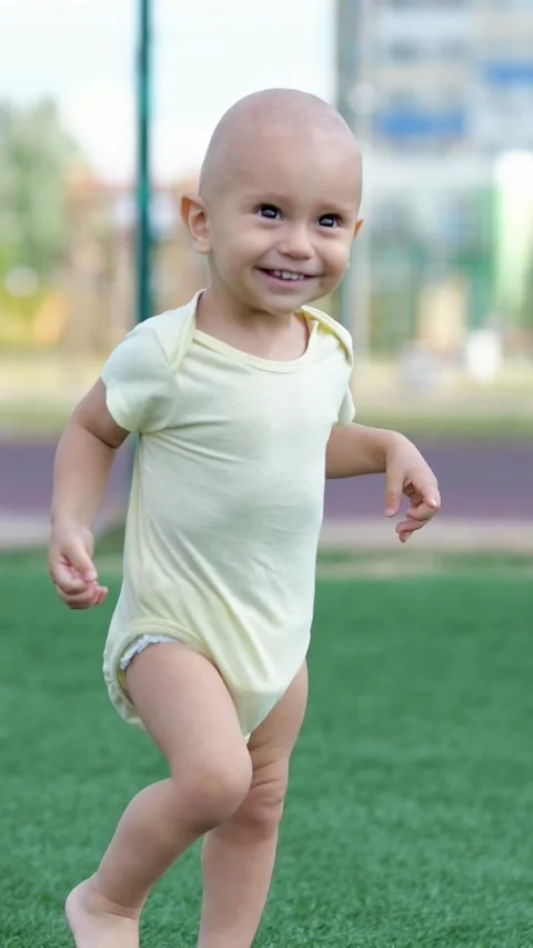 Adorable barefoot toddler taking first unsteady steps and happily running on Stock Footage 341432806