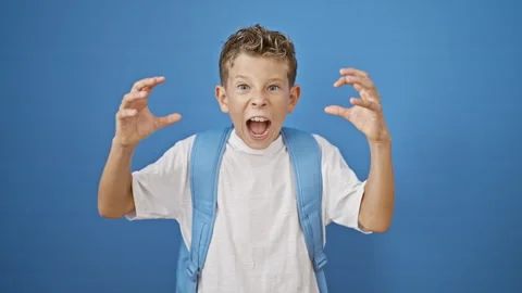 Adorable blond boy student standing, screaming loudly with serious expressi.. Video stock 255863491