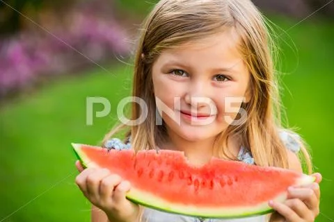 Adorable blonde girl eating watermelon outdoors Stock Photos