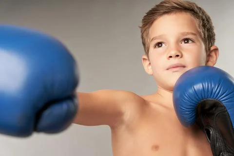 Adorable boy boxer practicing boxing punches in studio Stock Photos
