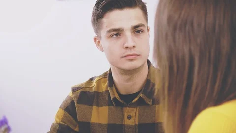 Adorable boy is sitting at the table in cafe. He is communicating with his Stock Footage 124277949